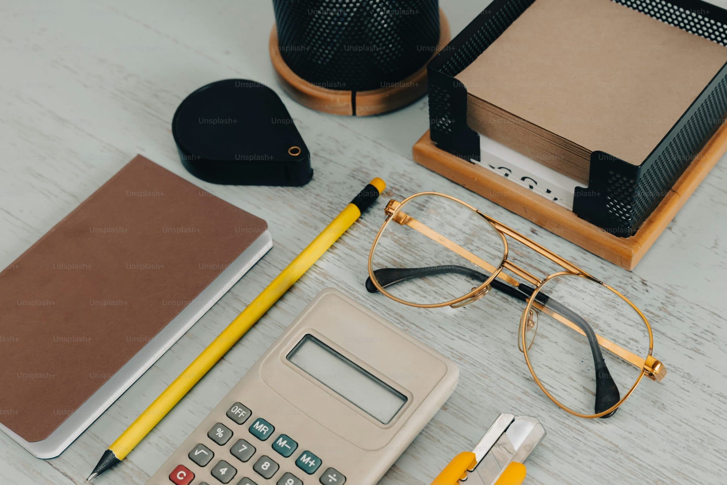 A ledger open on a desk beside a calculator